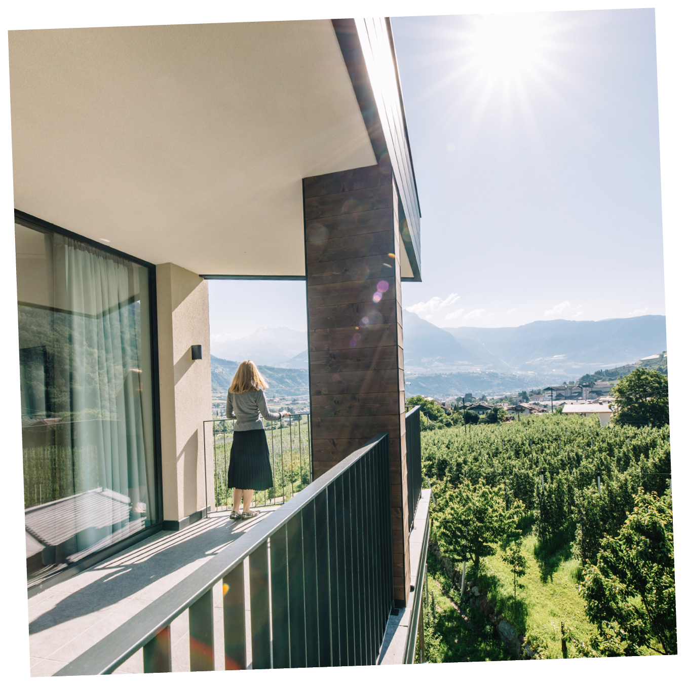 Eine Frau steht auf einen Balkon mit Blick auf die Berge im Hintergrund